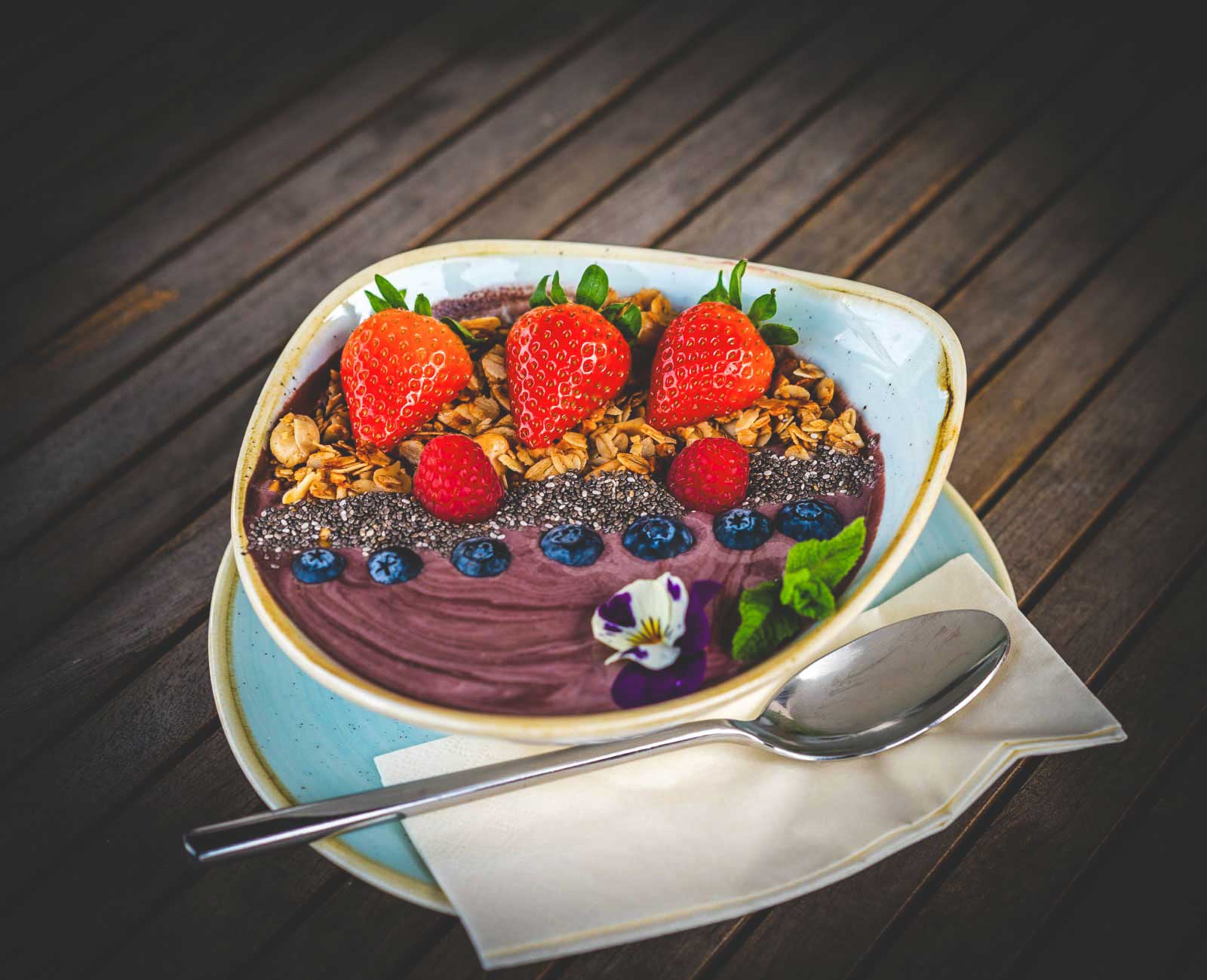 Joghurt-Bowl mit Früchten hübsch dekoriert mit Essblumen