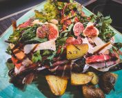 Brotmahlzeit mit geröstetem Brot, Speck, Feigen, Ruccola mit Ofenkartoffeln und Salat