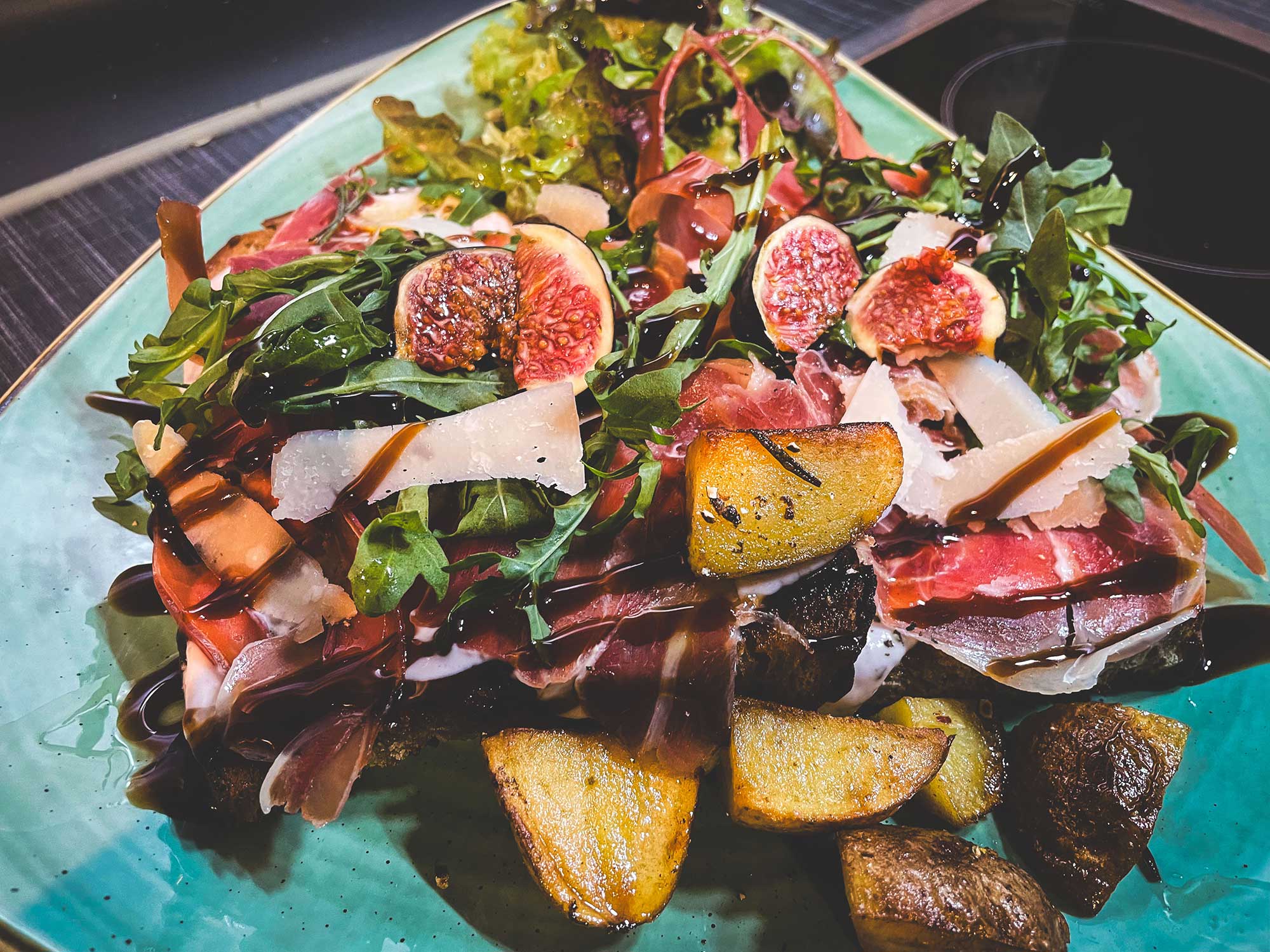 Brotmahlzeit mit geröstetem Brot, Speck, Feigen, Ruccola mit Ofenkartoffeln und Salat