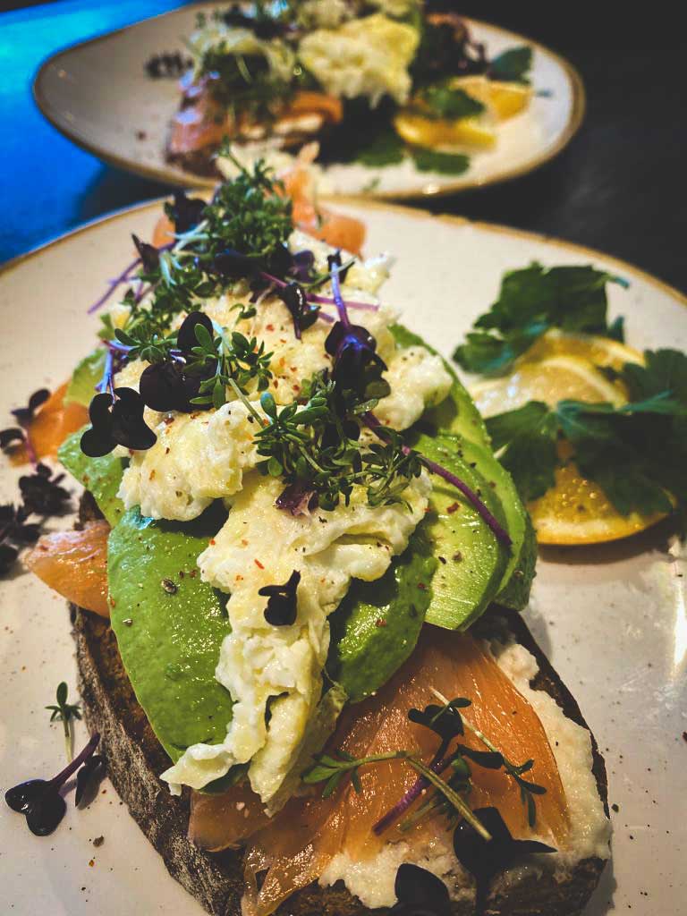 Lachsbrot mit Avocado und Ei dekoriert mit Essblumen