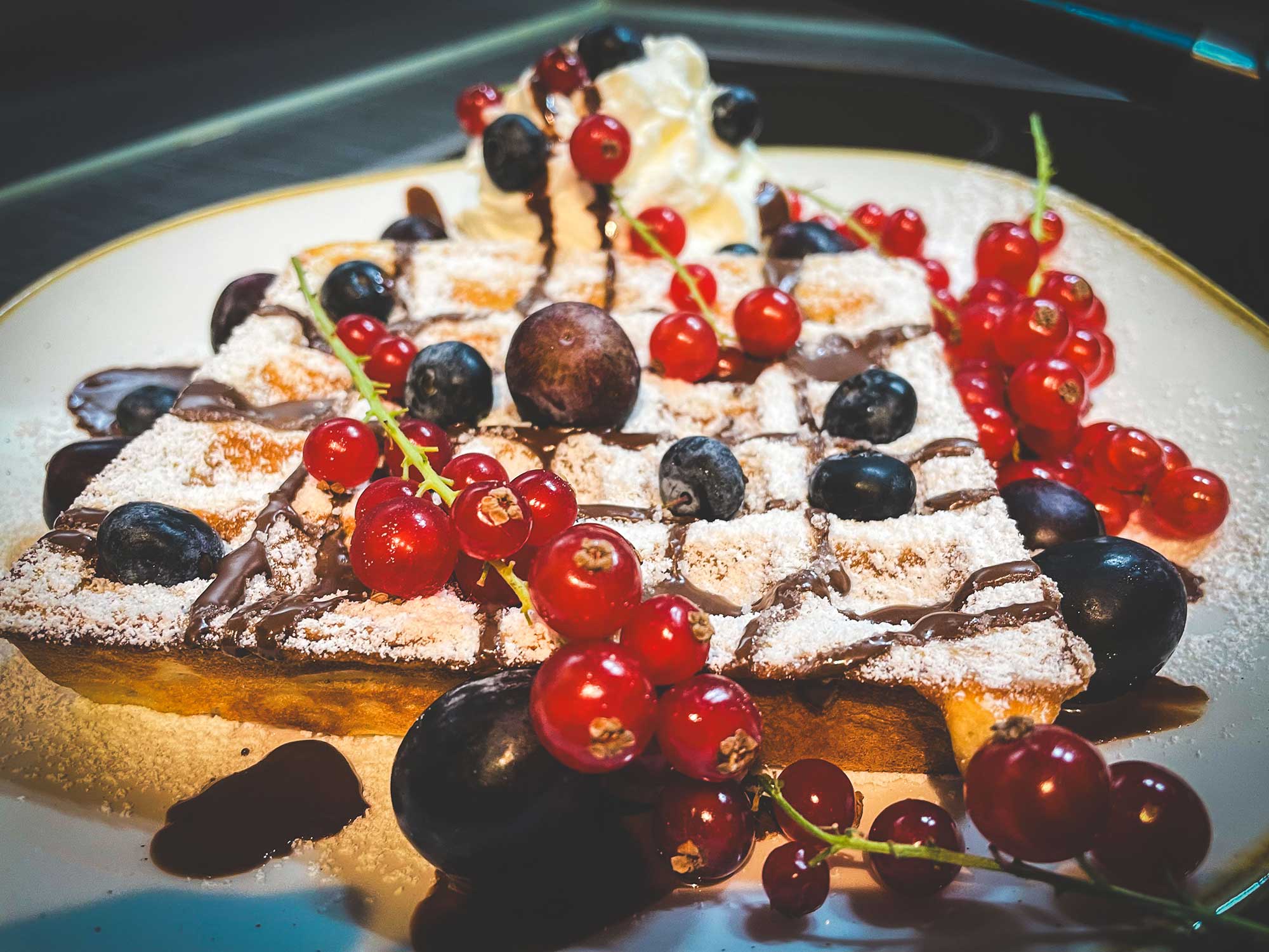 Süsse Waffel auf einem Teller hübsch dekoriert mit frischen Früchten